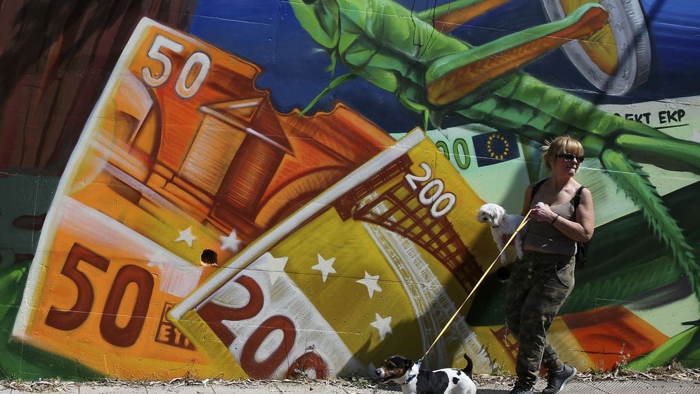 Foto: Una mujer pasa junto a una pintada de billetes de euro. (EFE)
